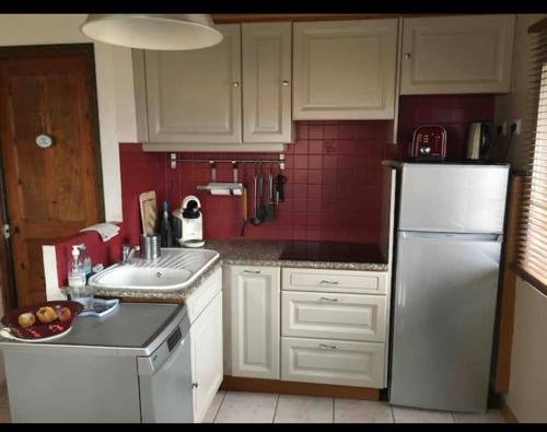 une cuisine avec un réfrigérateur blanc et un évier dans l'établissement Chalet les mimosas, au Lavandou