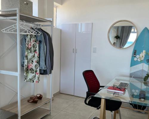 a room with a desk and a chair and a mirror at Ocean’s Edge in Umdloti