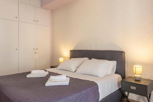 a bedroom with a large bed with two towels on it at 2 Bedroom condo with dream balcony in Athens