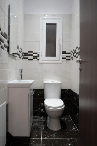a bathroom with a white toilet and a sink at 2 Bedroom condo with dream balcony in Athens