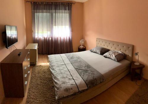 um quarto com uma cama, uma cómoda e uma janela em Apartment Sunny Bulevar em Mostar