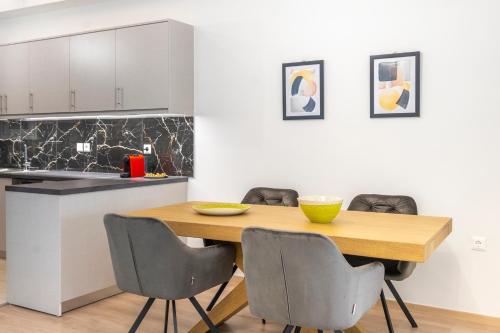 a kitchen and dining room with a wooden table and chairs at 2 Bedroom condo with dream balcony in Athens