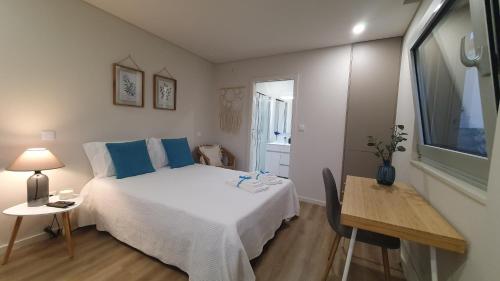 1 dormitorio con cama, mesa y ventana en Barrio Apartments, en Amares