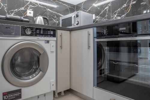 a laundry room with a washer and a microwave at 2 Bedroom condo with dream balcony in Athens