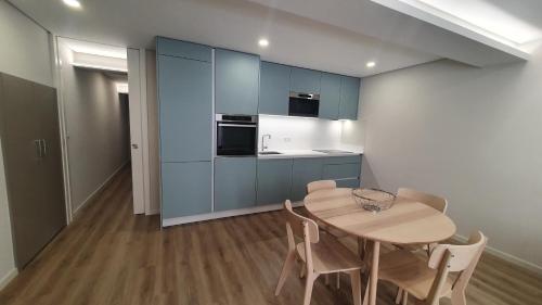 a kitchen with blue cabinets and a table and chairs at Barrio Apartments in Amares