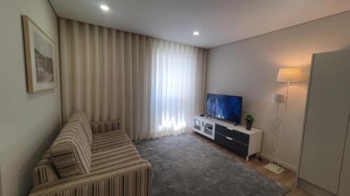 a living room with a couch and a television at Barrio Apartments in Amares