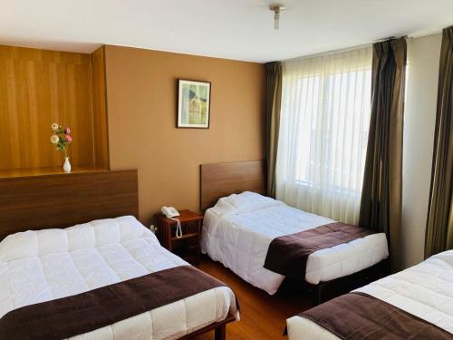 アレキパにあるHelena de Santa Maríaのベッド2台と窓が備わるホテルルームです。