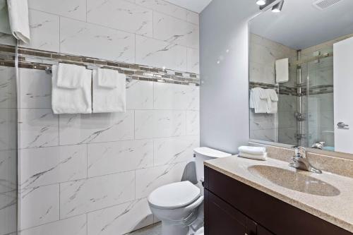 a bathroom with a toilet and a sink and a mirror at The Vista Inn in Kamloops