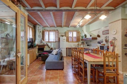 een keuken en een woonkamer met een tafel en stoelen bij Can MartiPol in La Pobla de Lillet