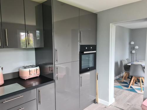 a kitchen with white cabinets and a pink appliance at 5 Berth bungalow in Mablethrorpe (Joe's Place) in Mablethorpe