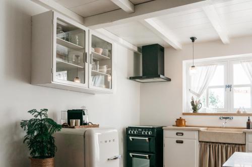  La cuisine est équipée de placards blancs et d'un réfrigérateur. dans l'établissement Logement Cornelia - Tholen, Zeeland, à Tholen