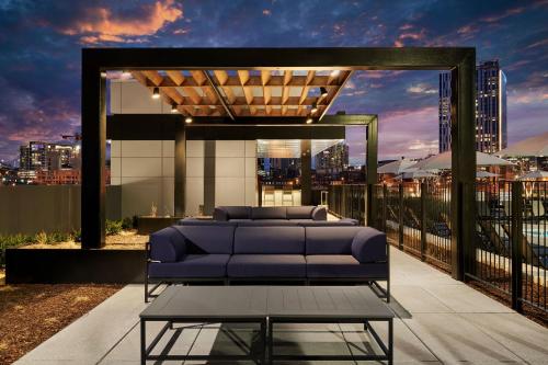 a couch on a balcony with a view of a city at Sentral SoBro in Nashville