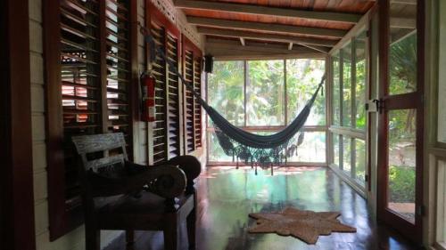 a room with a hammock and a chair in a house at Tingalaya's Retreat in Negril