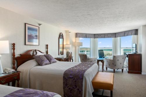 Habitación de hotel con cama, mesa y sillas en The Sparhawk Oceanfront Resort en Ogunquit