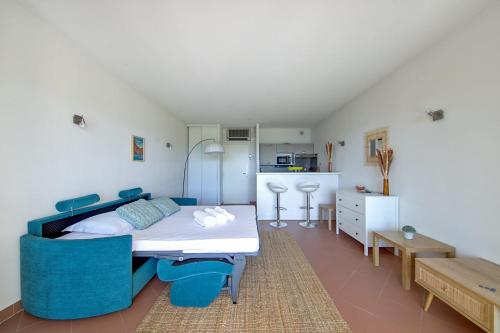 - une chambre avec un lit et des chaises bleues dans l'établissement Studio Rossi - Ajaccio - Welkeys, à Ajaccio