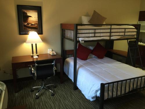 a hotel room with a bunk bed and a desk and a desk at Hawthorn Suites by Wyndham Rancho Cordova/Folsom in Rancho Cordova