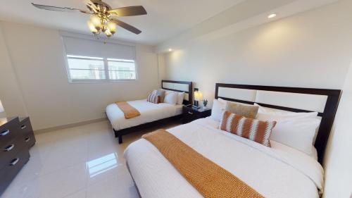 a bedroom with two beds and a ceiling fan at Ocean Reserve Condo by FlatsAway in Miami Beach