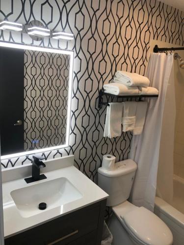 ein Badezimmer mit einem Waschbecken, einem WC und einem Spiegel in der Unterkunft The Spot at Porpoise Bay in Sechelt
