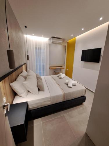 una camera da letto con un grande letto con cuscini bianchi di Pleasant Stay a Kavala
