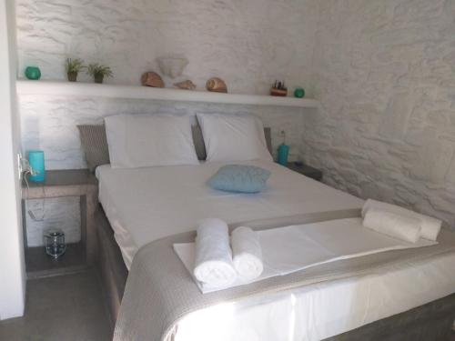 a bedroom with a white bed with towels on it at SIRENA in Kithnos