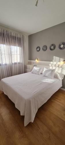 een groot wit bed in een slaapkamer met een raam bij Mirador de Luciana in Málaga