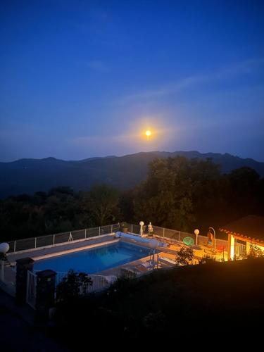 a swimming pool with the sunset in the background at villa calme et detente in Montbolo