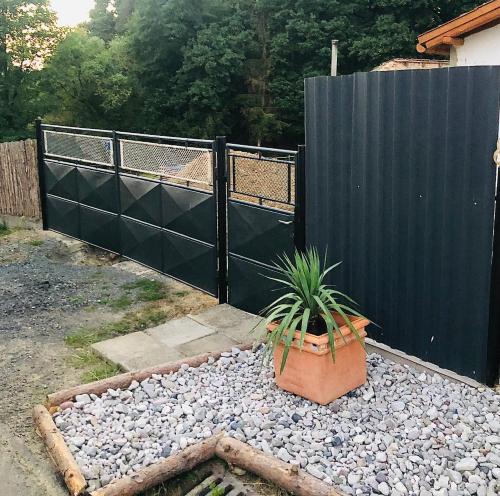 a black fence with a potted plant in front of it at Apartman u lesa in Horšovský Týn
