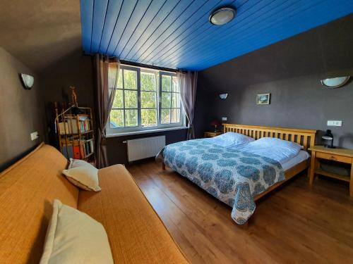 a bedroom with a bed and a blue ceiling at Waterfront Villa Artvė with sauna - self check-in in Pervalka
