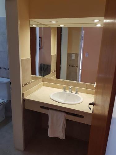 a bathroom with a sink and a large mirror at Nuevos Aires in Las Grutas