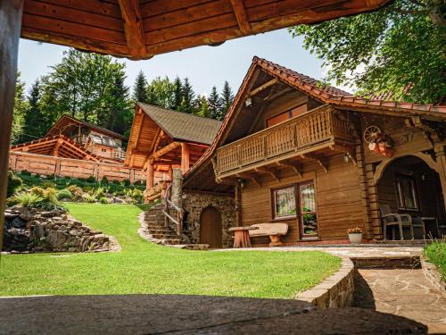 drewniany domek z werandą i dziedzińcem w obiekcie Tworzówka - Ekskluzywne Domy w górach w mieście Żabnica