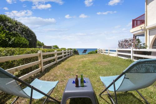eine Terrasse mit Stühlen, einem Grill und Meerblick in der Unterkunft Wonderful apartment with direct access to the beach - Bidart - Welkeys in Bidart