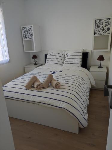 une chambre avec un lit blanc avec deux serviettes dessus dans l'établissement Maison proche du centre ville, à Pornic