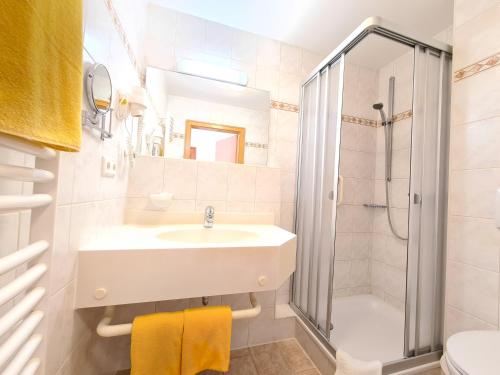 a bathroom with a sink and a shower at Thermenhotel Tannenhof - Ihr Wohlfühl-Hotel in Bad Füssing