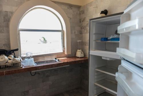 eine Küche mit einem Waschbecken und einem Bogenfenster in der Unterkunft Villablanca Garden Beach Hotel in Cozumel