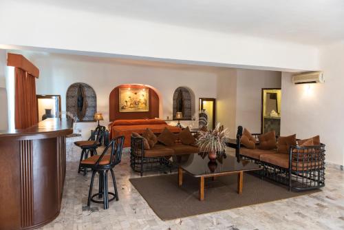 a living room with a bed and a table and chairs at Villablanca Garden Beach Hotel in Cozumel