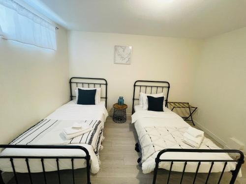 two beds sitting next to each other in a room at Adorable 2-Bedroom Basement in Vancouver in Vancouver