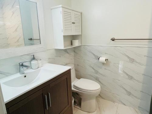 a bathroom with a white sink and a toilet at Adorable 2-Bedroom Basement in Vancouver in Vancouver