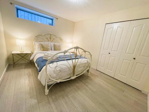 a bedroom with a white bed and a window at Adorable 2-Bedroom Basement in Vancouver in Vancouver