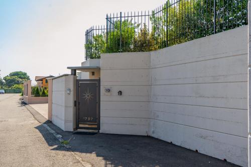 a white building with a door and a fence at B&B Margante - MXP - Breakfast gluten free su richiesta in Somma Lombardo