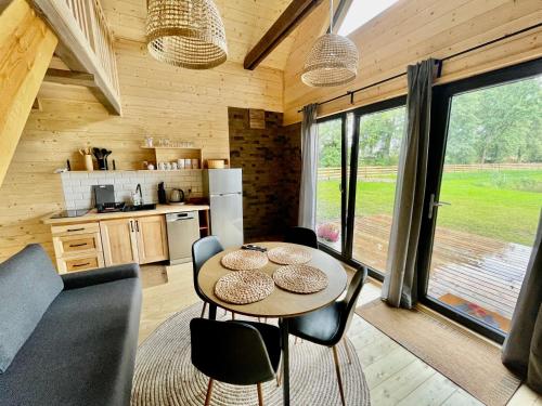 a kitchen and dining room with a table and chairs at Wypoczynek pod Lipami in Ruciane-Nida