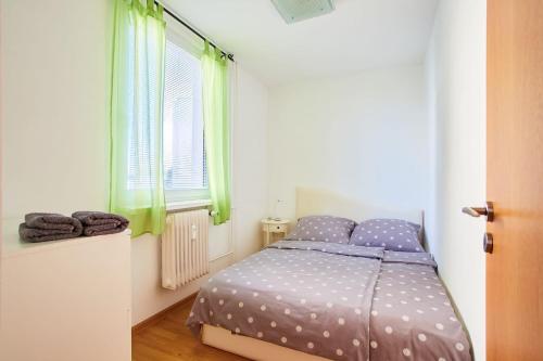 een slaapkamer met een bed met polka dot lakens en een raam bij Apartman Ortenova 74 in Kutná Hora
