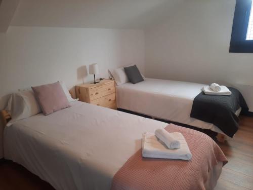 una camera con due letti con sopra asciugamani di Casa en vigo a 5 min playas a Vigo