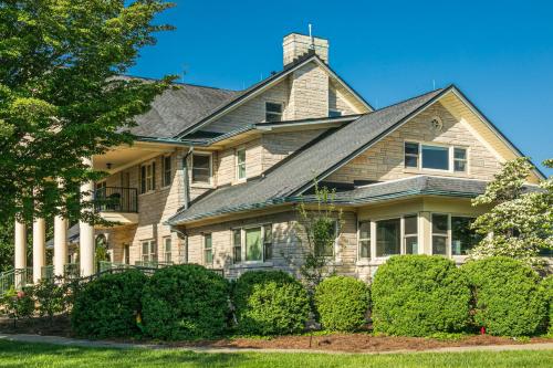 une grande maison avec des buissons devant elle dans l'établissement SKYLARANNA Resort & SPA, à Hendersonville