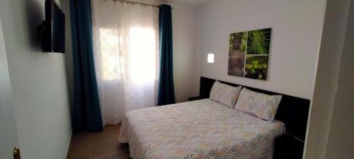 ein kleines Schlafzimmer mit einem Bett und einem Fenster in der Unterkunft Luminoso y bonito apartamento con piscina en frente del mar in Los Cristianos