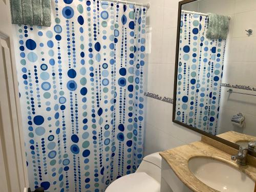 a bathroom with a toilet and a shower curtain at Casa de campo, con hermosa vista al mar in Tongoy