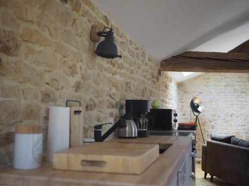 a kitchen with a stone wall and a counter top at Gite Pays de Joie 