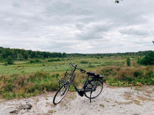 a bike parked on a dirt road in a field at Mimi's natuurhuisje in Lanaken