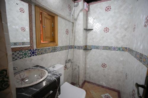 uma casa de banho com um lavatório e um WC em Dar Kenz Fes em Fez