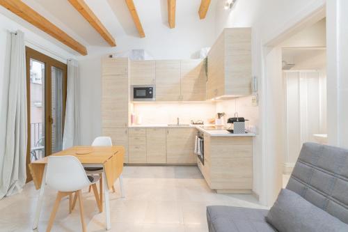 a kitchen and dining room with a wooden table and chairs at NICE CITY CENTER APARTMENT in Vilanova i la Geltrú
