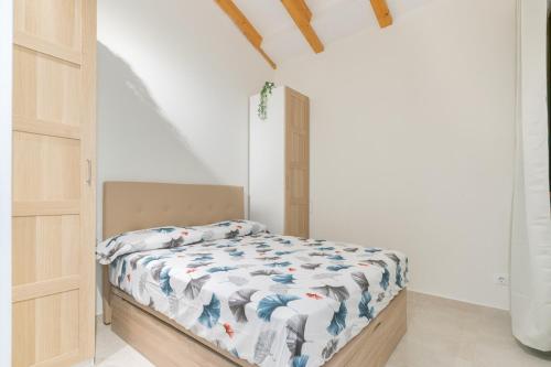 - une chambre avec un lit dans une pièce aux murs blancs dans l'établissement NICE CITY CENTER APARTMENT, à Vilanova i la Geltrú